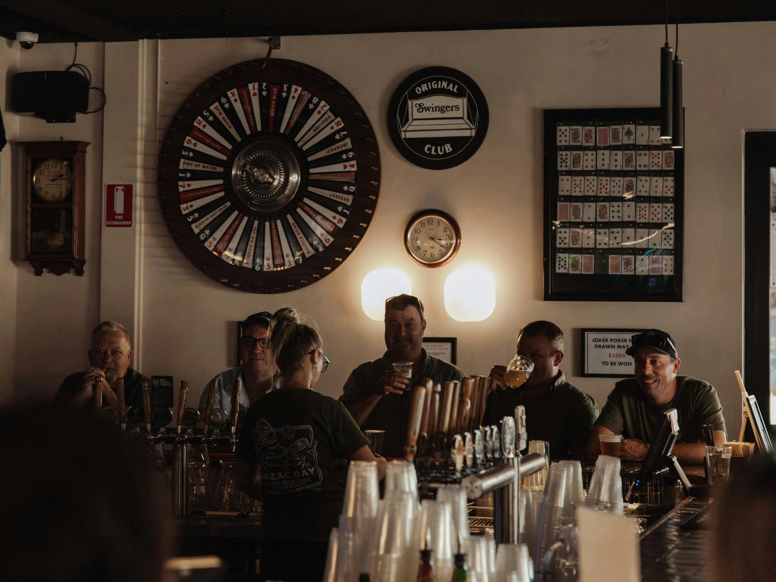 Patrons seated and standing at the main bar inside Great Southern Hotel Berry with beer taps and wal