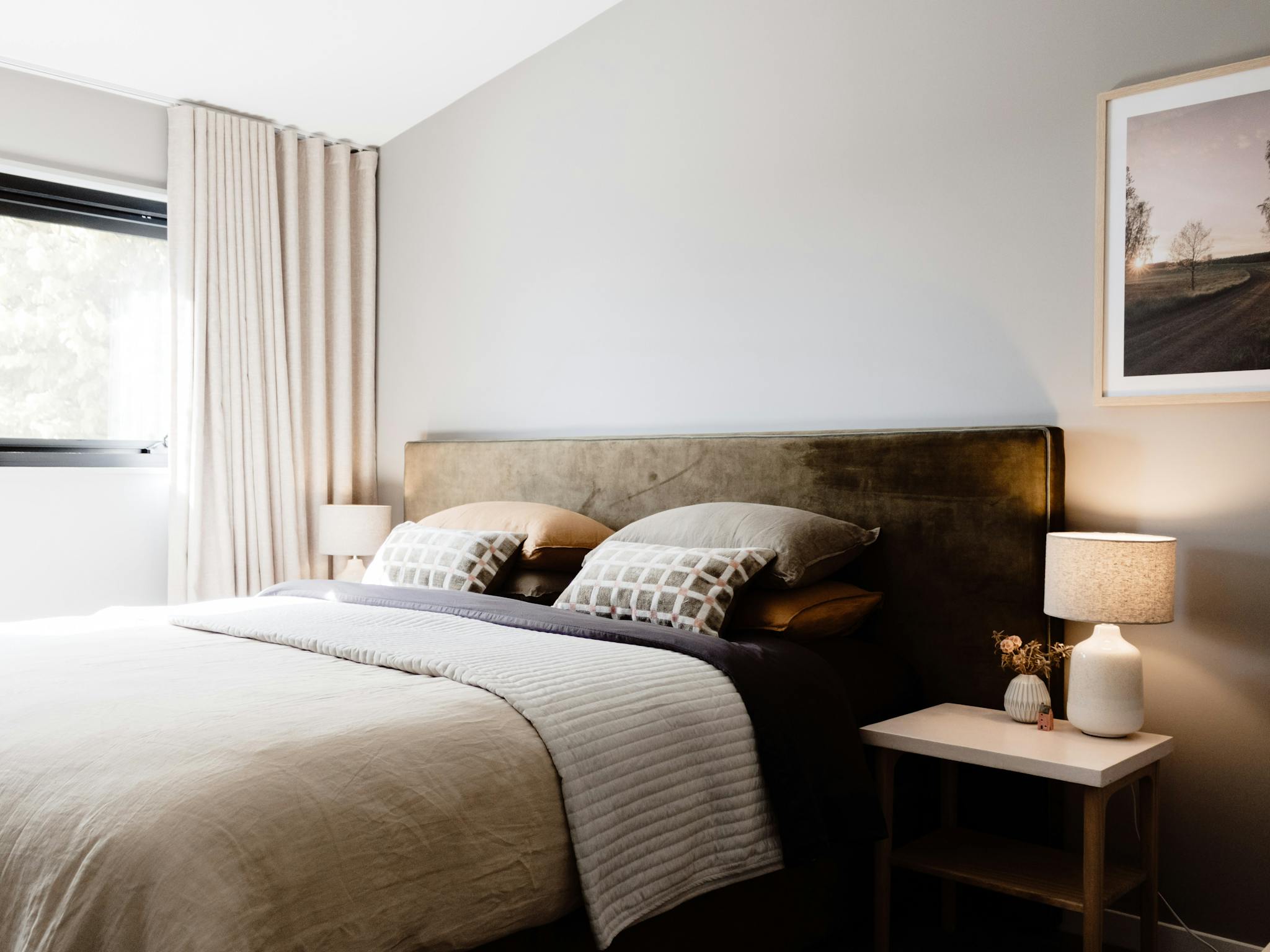 Roam Merrijig King sized bed with olive velvet bedhead, warm grey walls, artwork and european linens