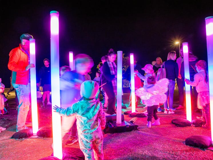 Sonder art installation with people amongst light up posts