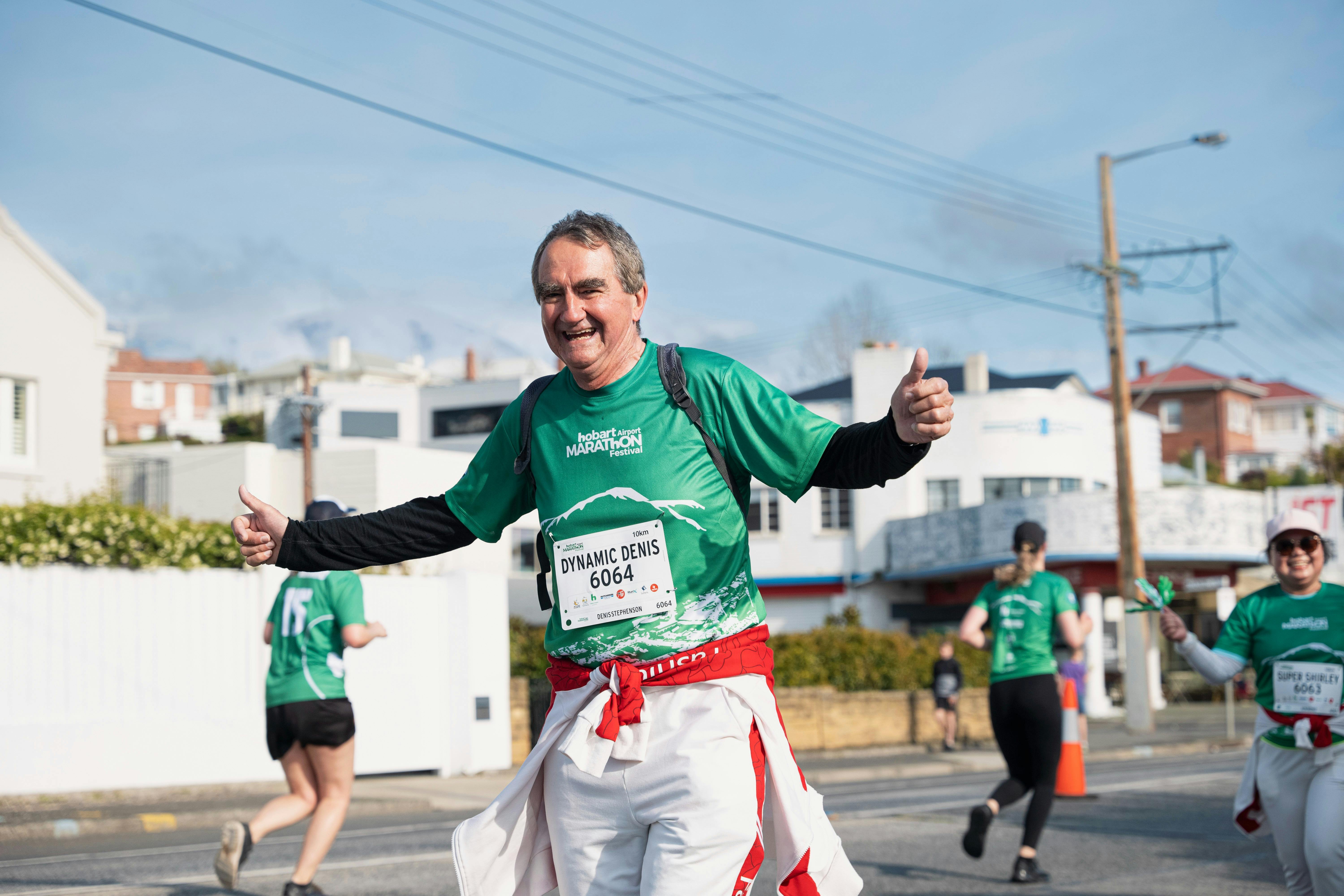 Male runner smiling with his arms open