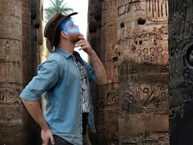 Man with a glowing VR headset exploring ancient ruins in an escape room.