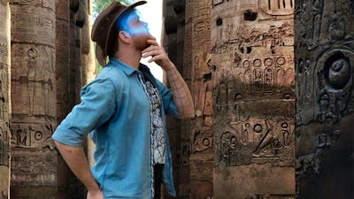 Man with a glowing VR headset exploring ancient ruins in an escape room.