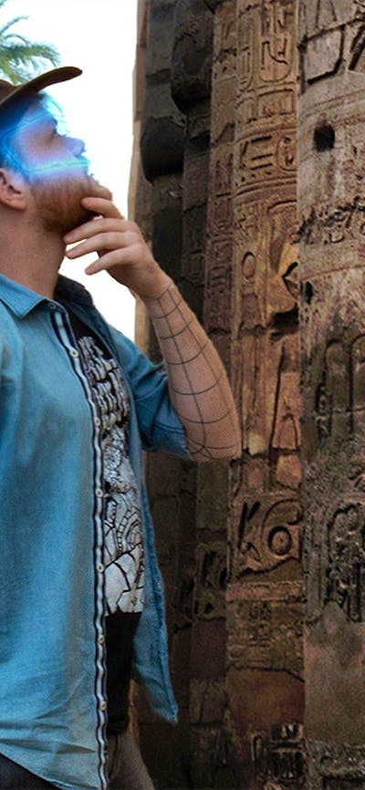 Man with a glowing VR headset exploring ancient ruins in an escape room.