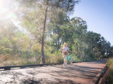 Riding push bike along Eddie Santaguiliana Way boardwalk