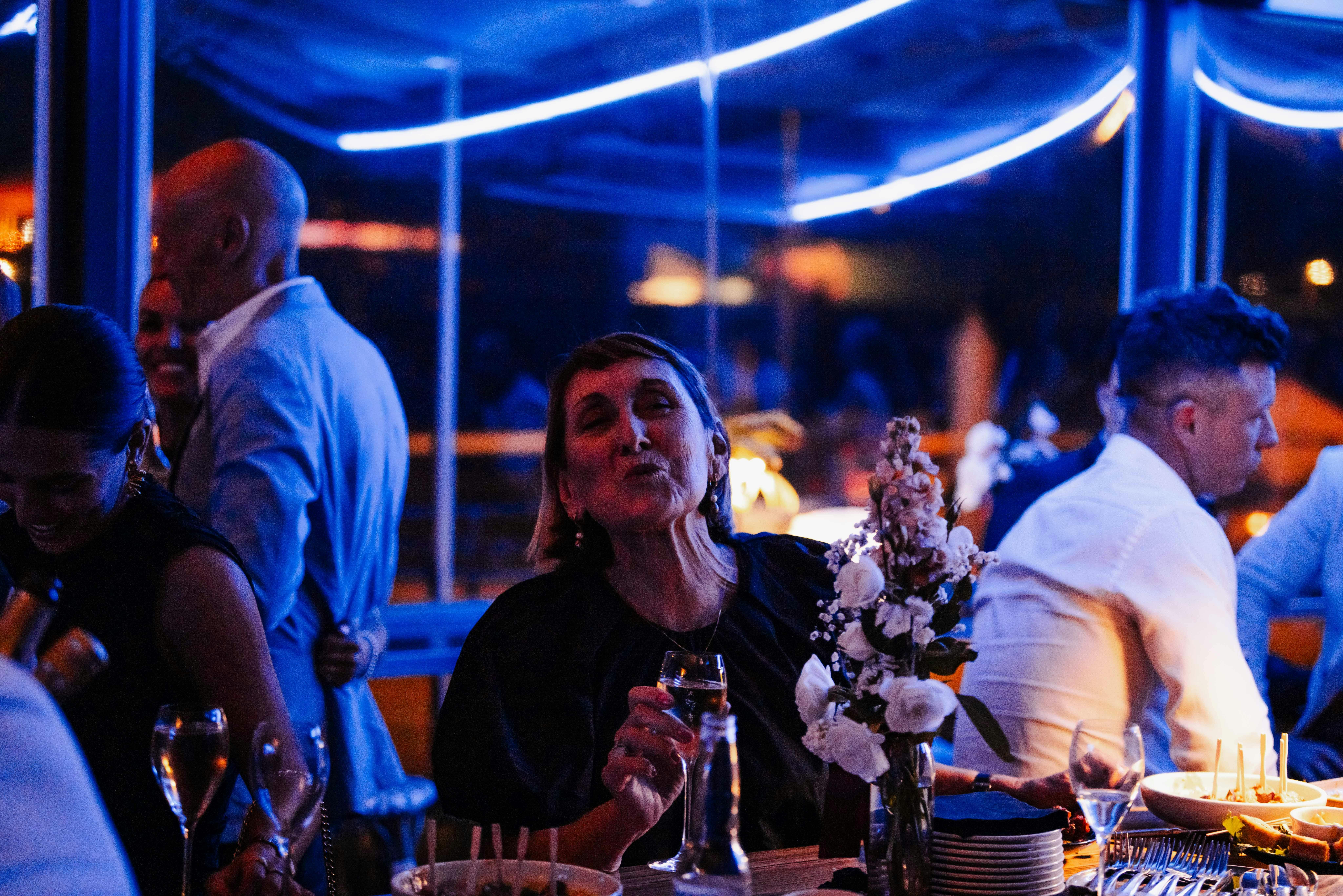Customer blowing a kiss to the camera while enjoying a glass of sparkling at Mudbar Restaurant