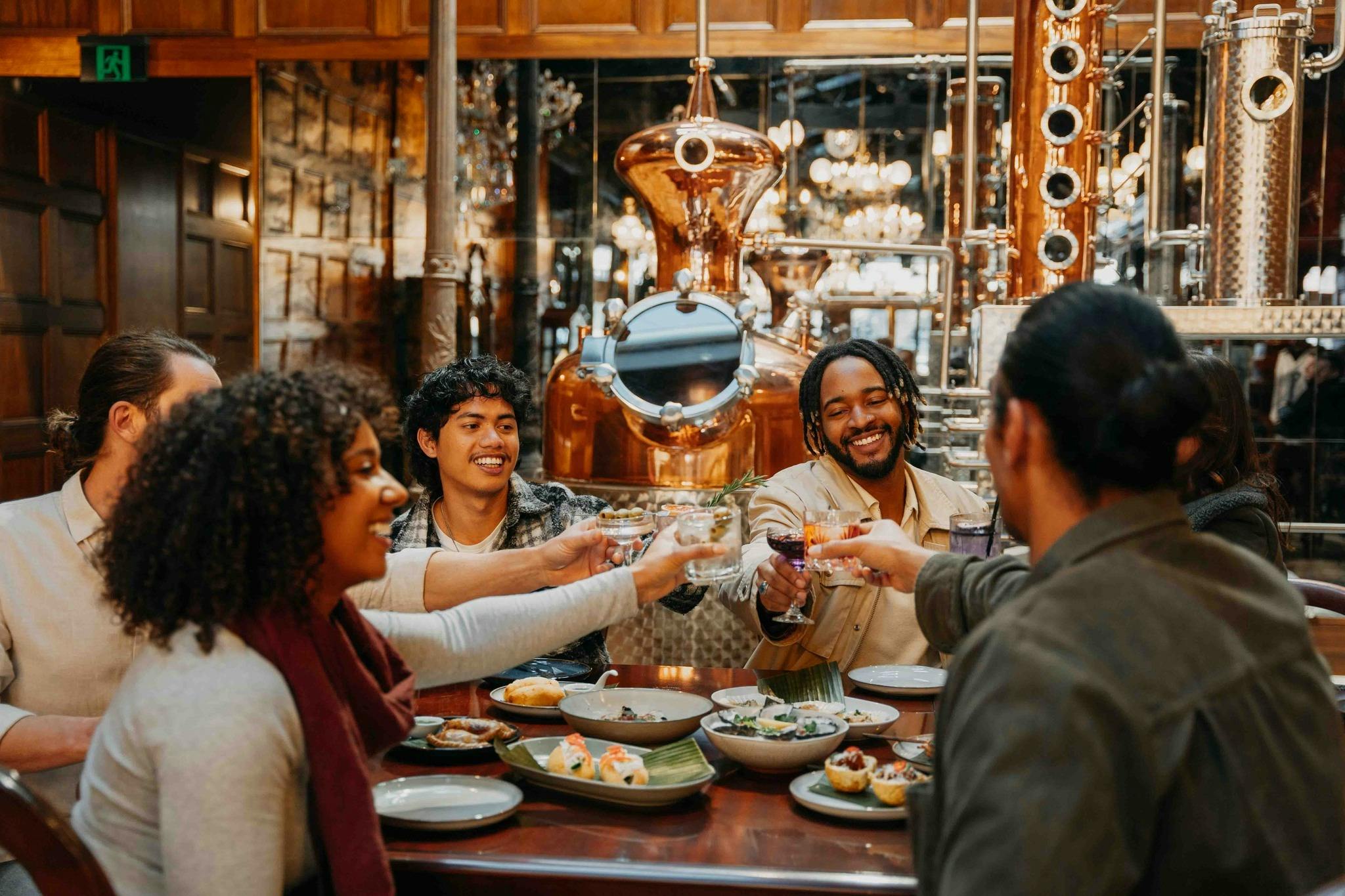 group of people in a venue, clinking their glasses together