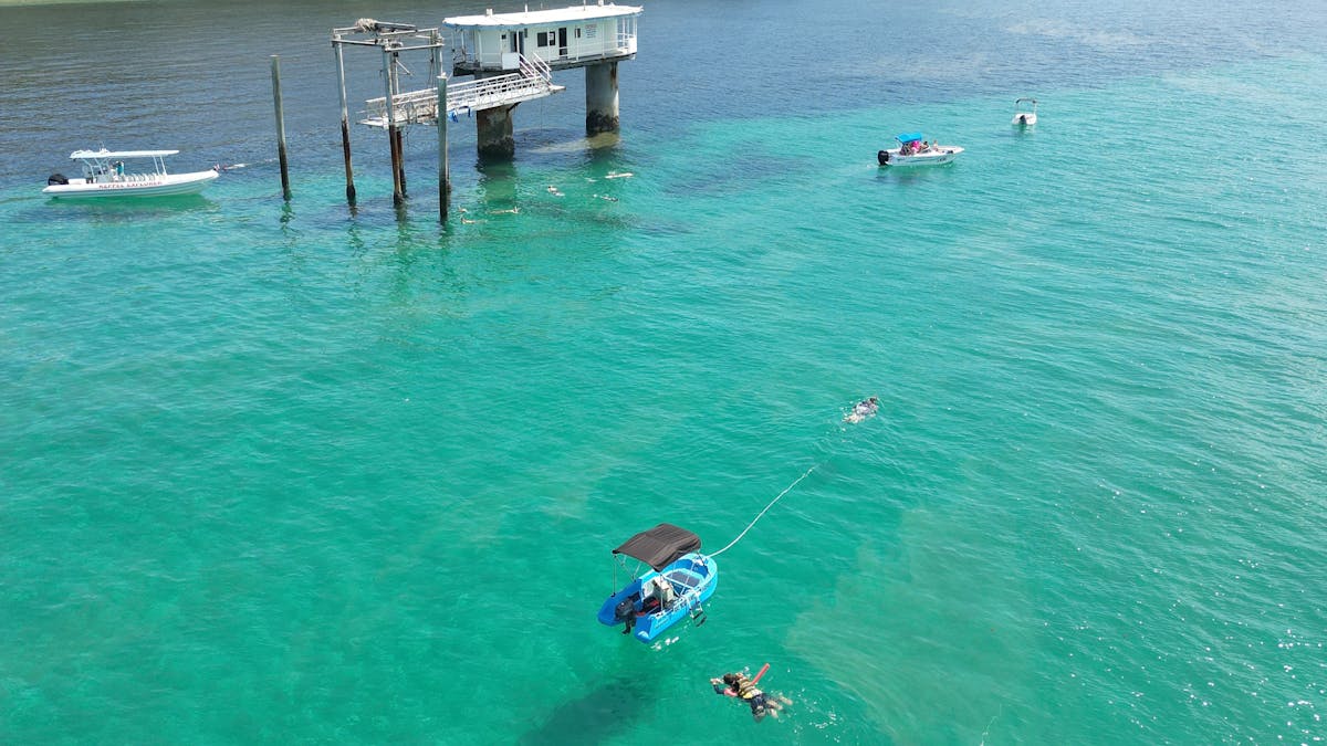 Two hire boats with guests snorkelling off Great Keppel Island, QLD.