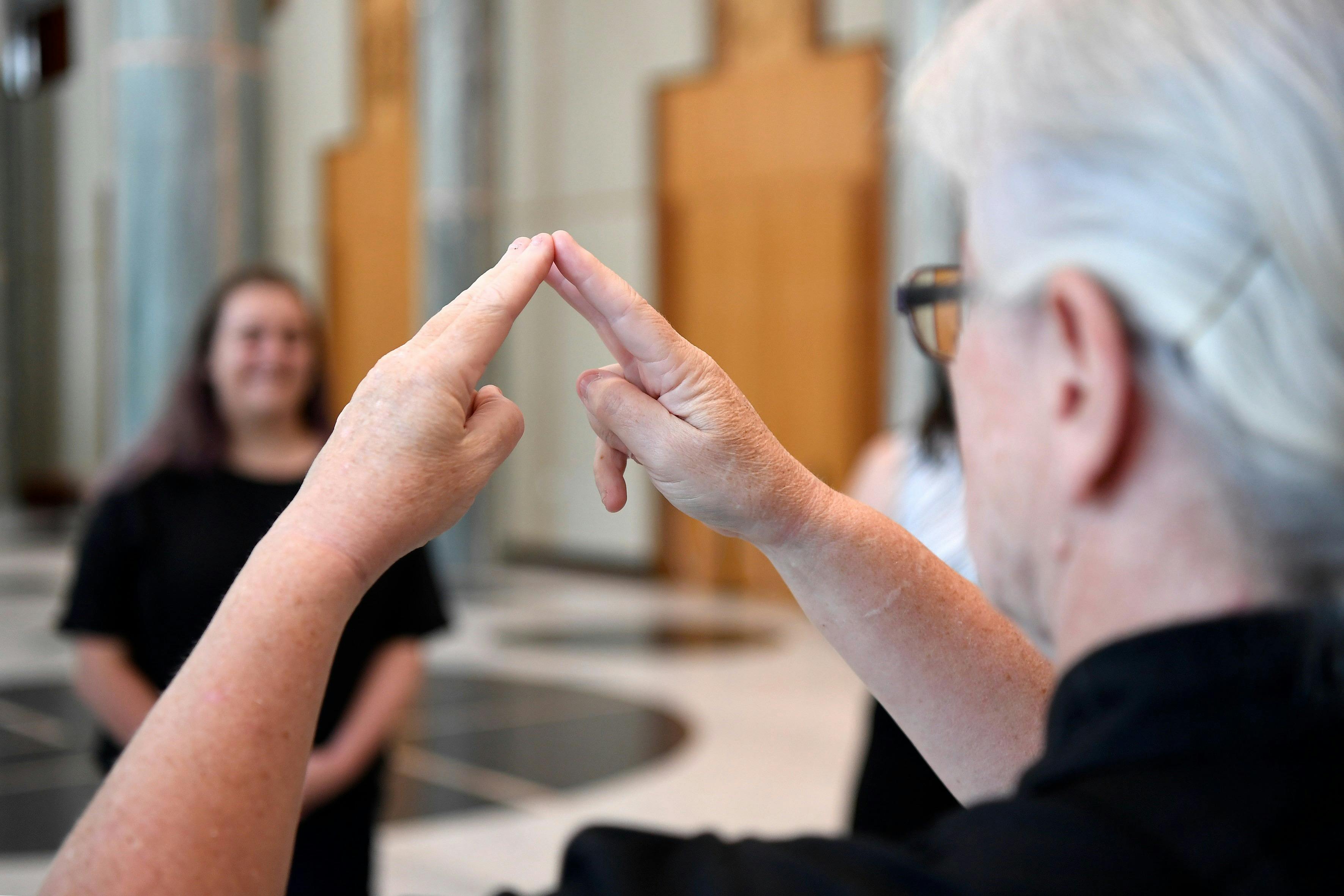 A woman signing in AUSLAN on a tour at Parliament House.