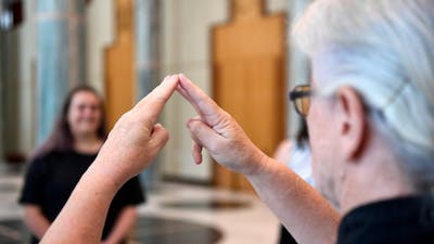 A woman signing in AUSLAN on a tour at Parliament House.