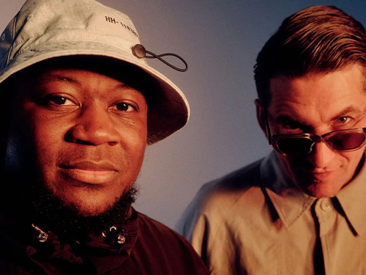 Two males in the photo. One is wearing a bucket hat and one is wearing sunglasses.