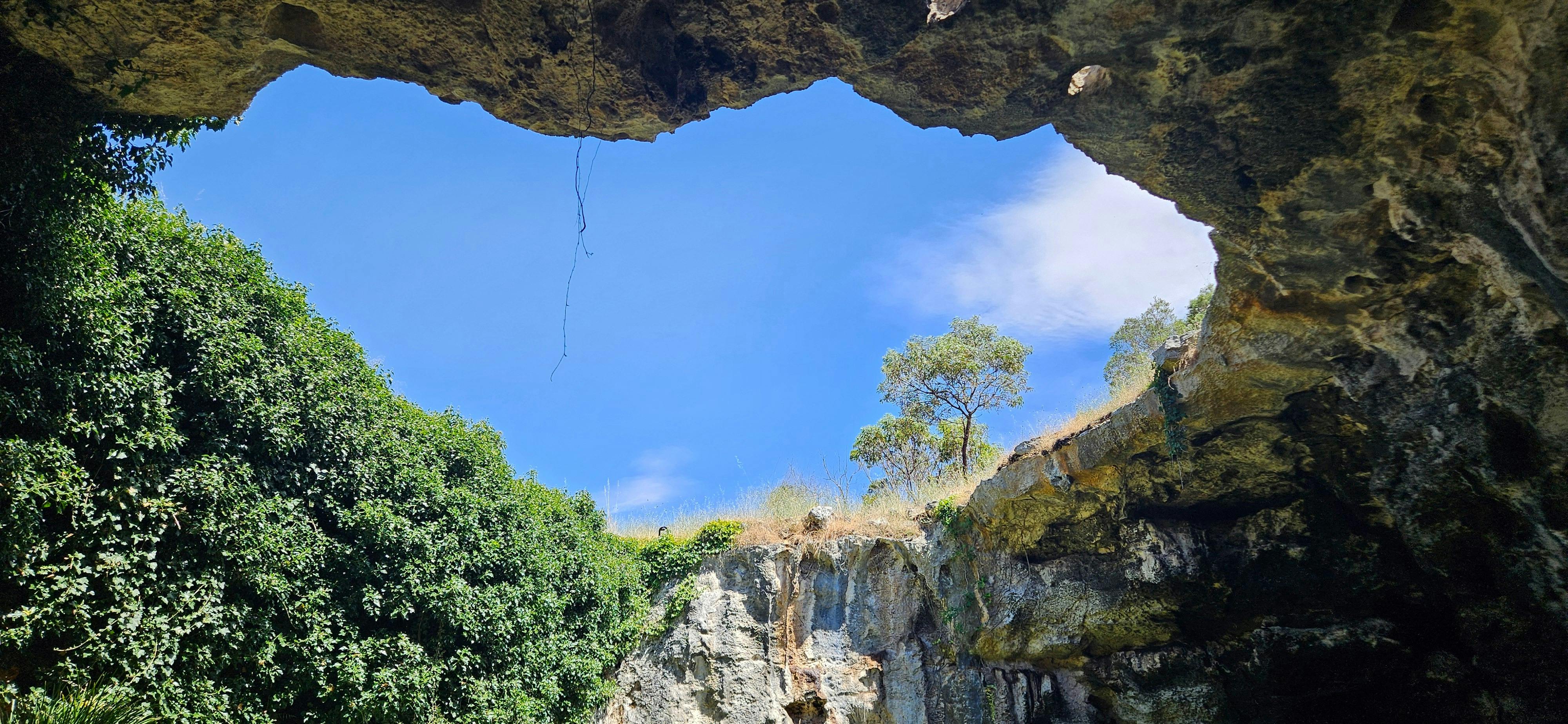 Coonawarra Experiences - a limestone cave opening to blue sky and rugged rock walls