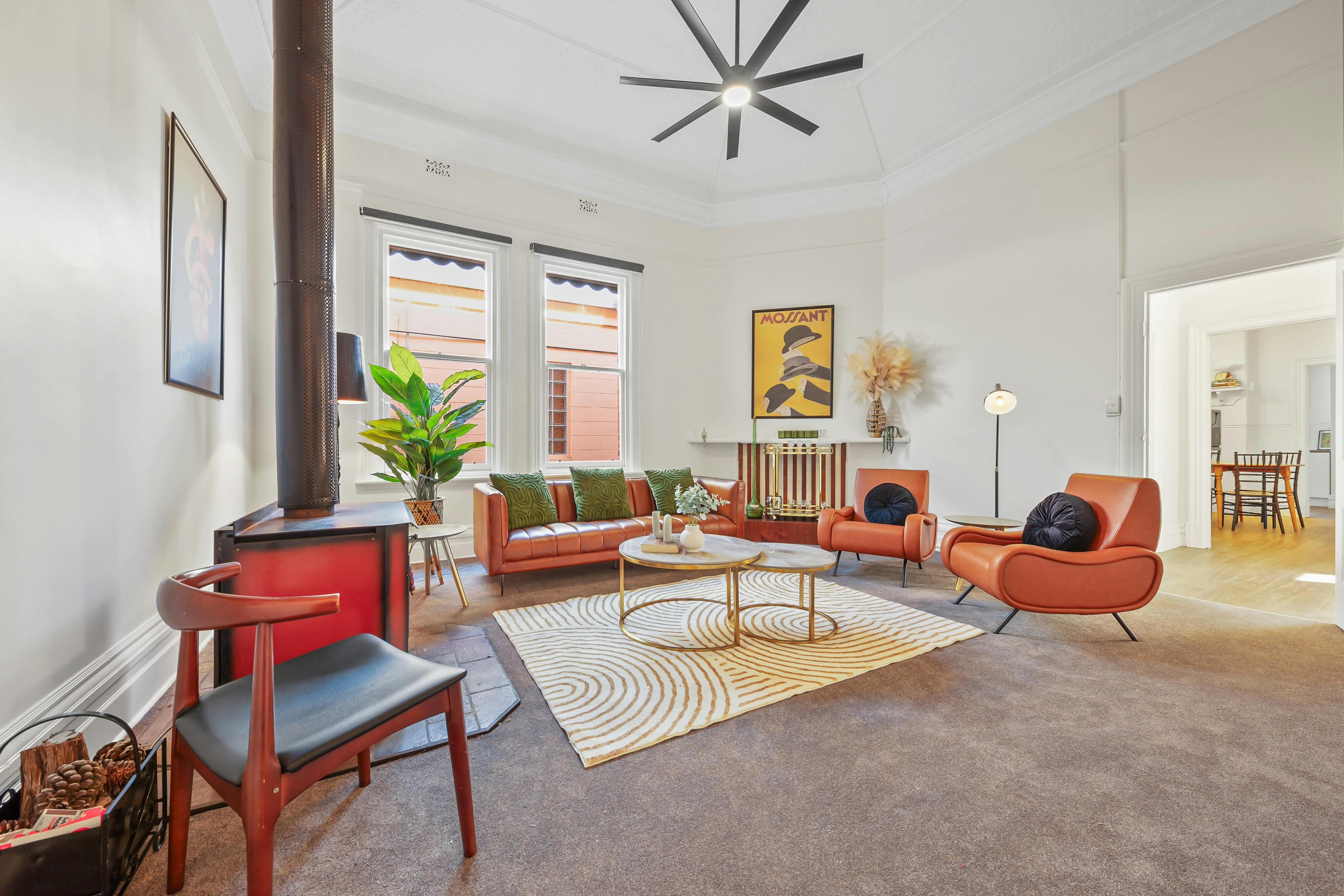 Wood fireplace, 3 seater leather lounge, 2 armchairs, ceiling fan