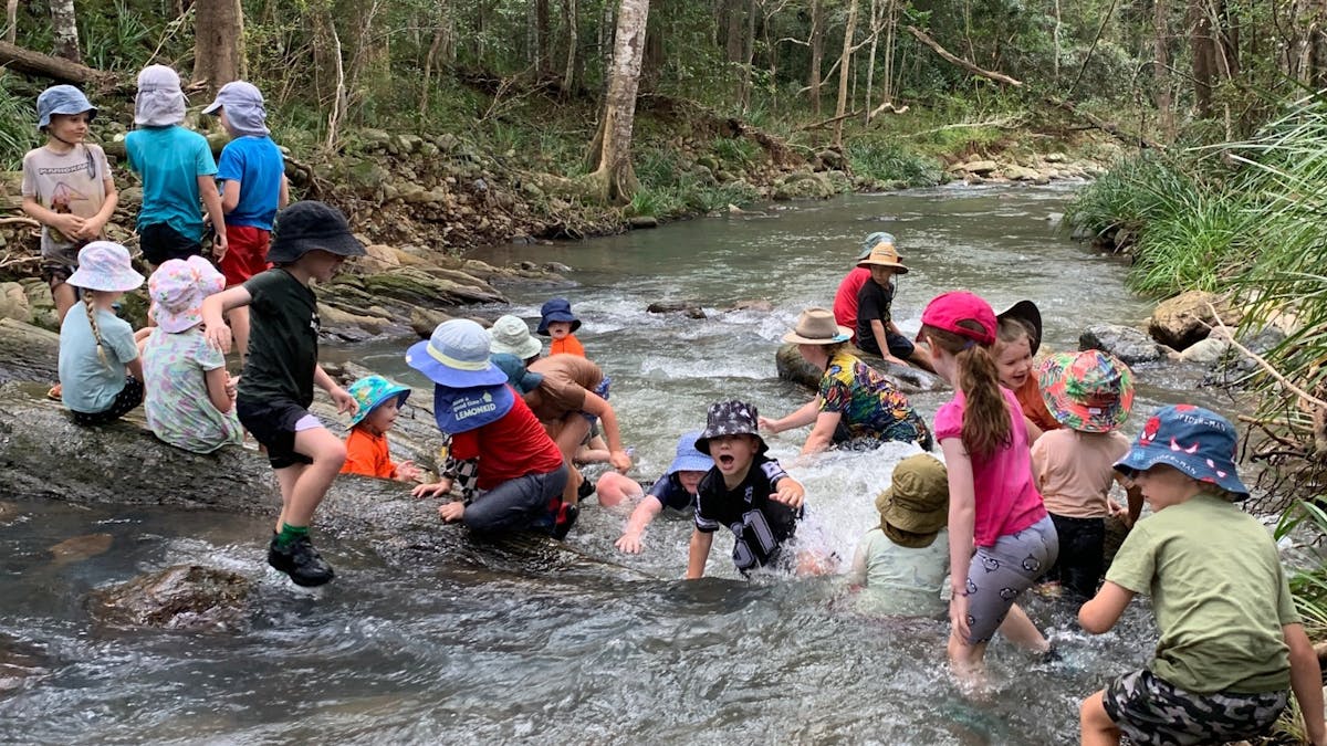 Children playing in creek at Birdwings Forest School Kids Holiday Nature Adventures Gold Coast Hinte