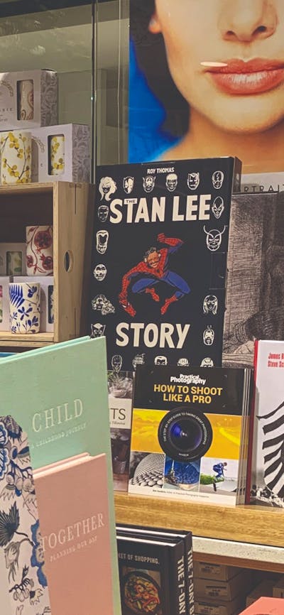 Boxed Stationary and books in foreground, ceramic tumblers and vases with botanical designs on raise
