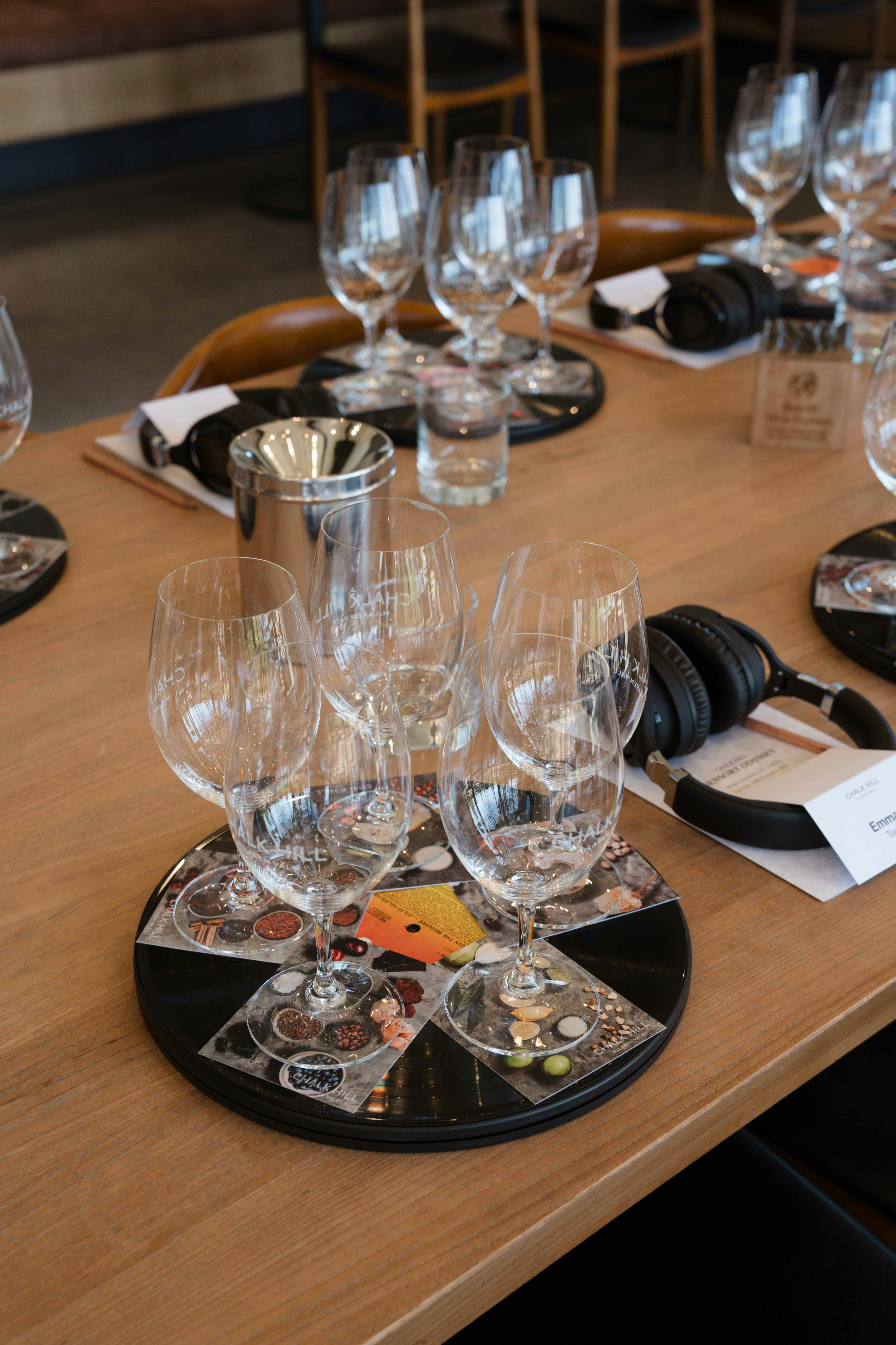 Wine glasses set for a tasting on a vinyl record next to headphones