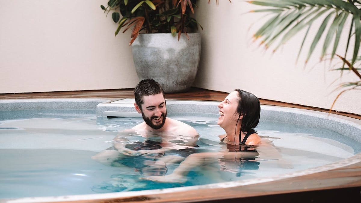 Two people laughing in the hot pool