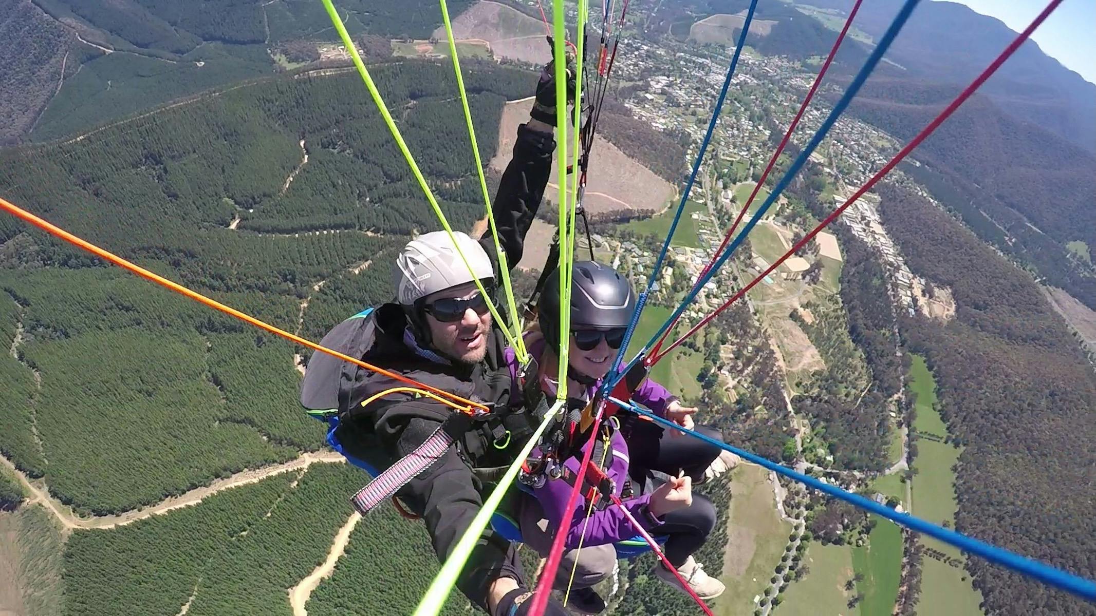 Looking down the lines of a Paraglider to the pilot and passenger