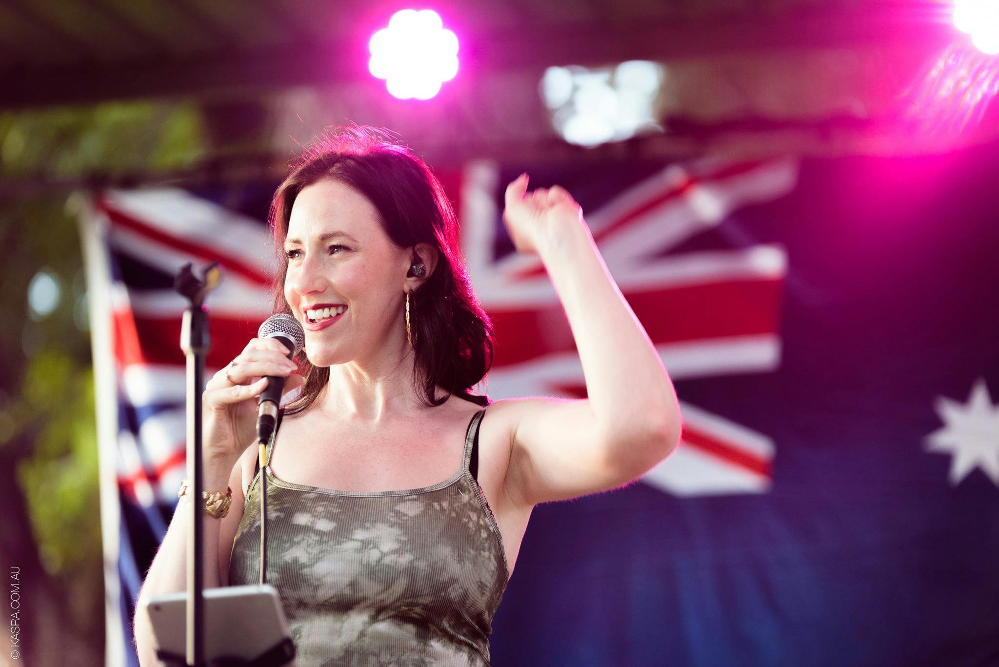 Female vocalist with Australian flag in background