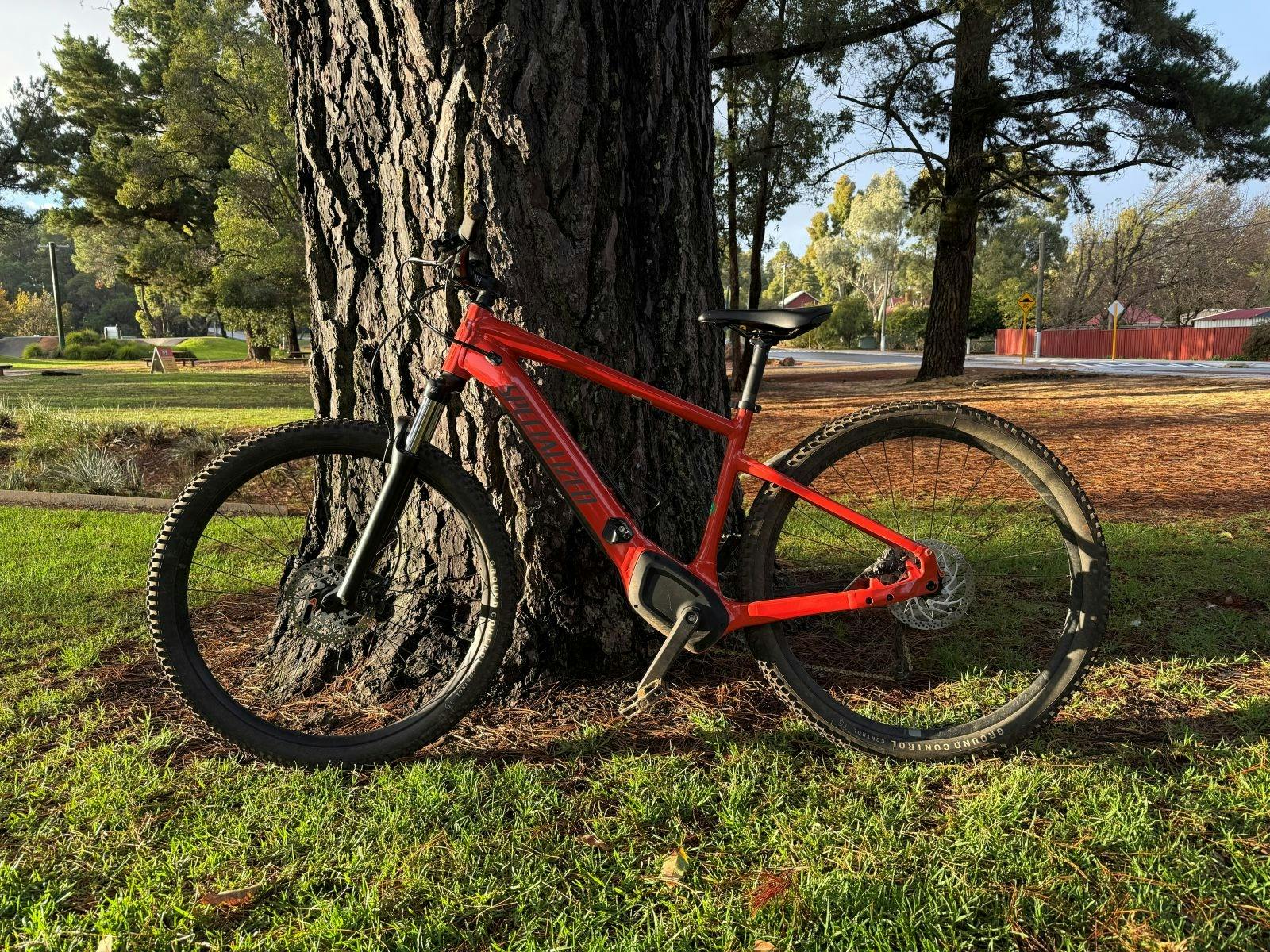 Tier 4 Electric assist mountain bike leaning against tree