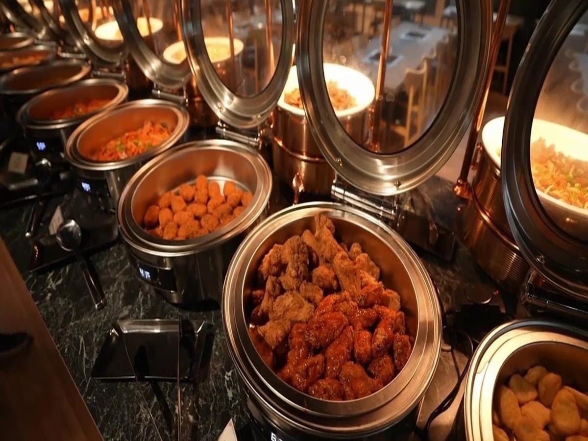 “Close-up of fried chicken varieties including soy garlic and spicy Korean wings at the buffet.”