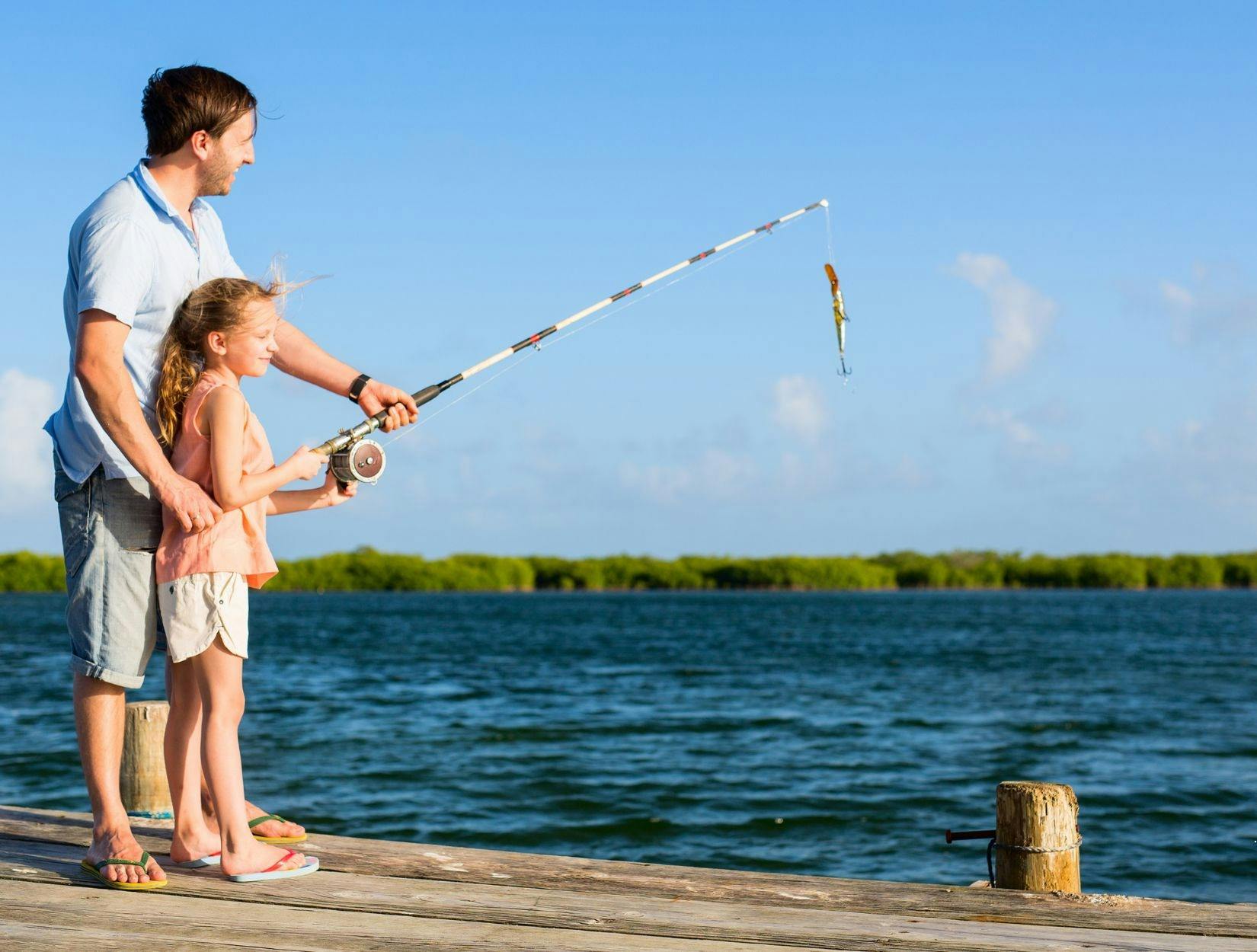 father and daughter fishing on a wharf