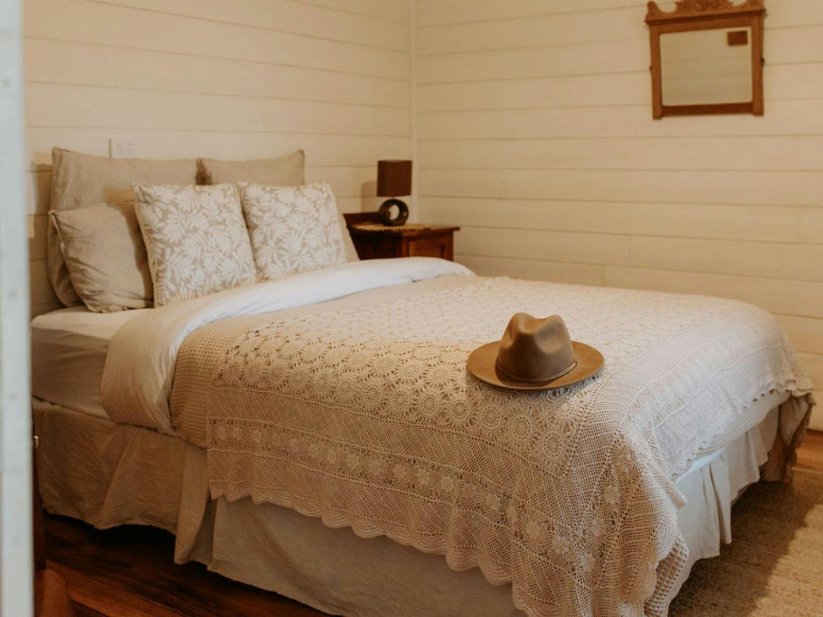 queen sized bed in Singline Cottage bedroom two with a hat on the bedspread