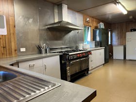 Commercial kitchen with sink, ovens, fridge/freezer
