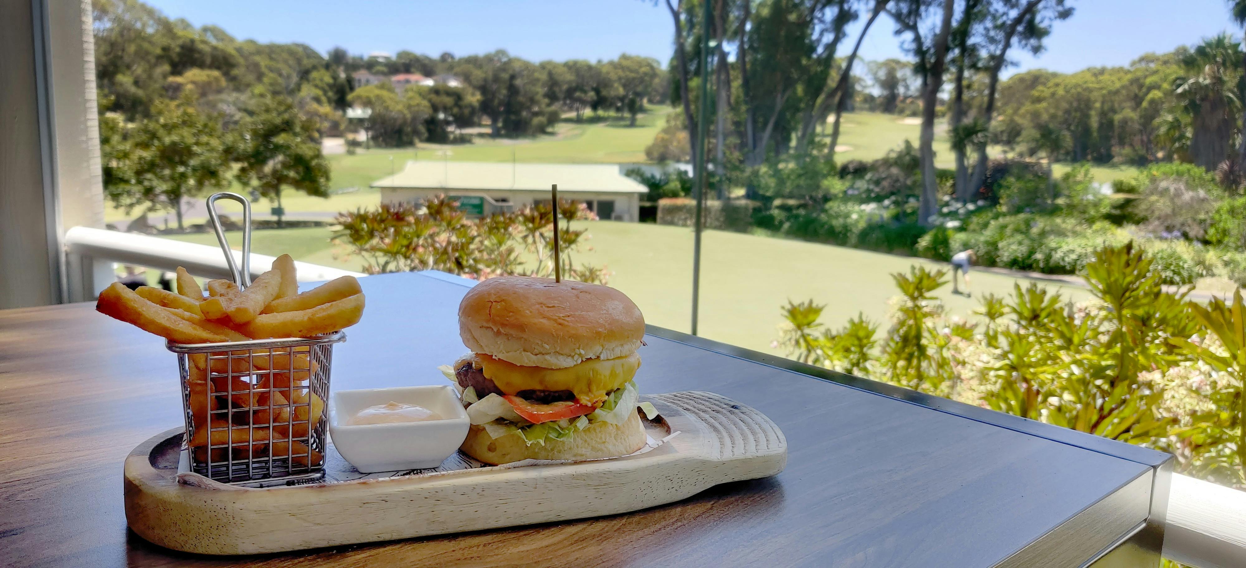 A yummy burger and chip combo overlooking the stunning greens