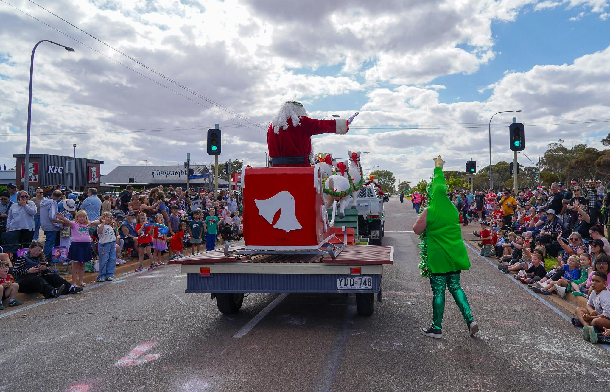 Father Christmas Standing on sleigh inthe middle of the road wavin to crowd on both sides