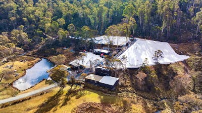 Corin Forest as seen by a drone. There are 3 large patches of snow & a small dam surrounded by trees