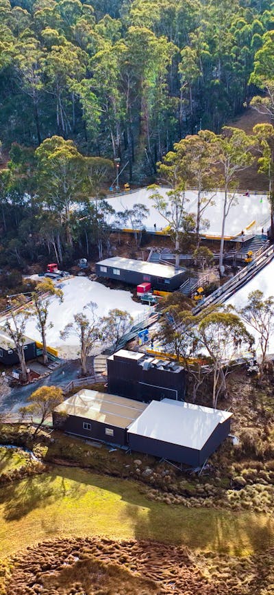 Corin Forest as seen by a drone. There are 3 large patches of snow & a small dam surrounded by trees