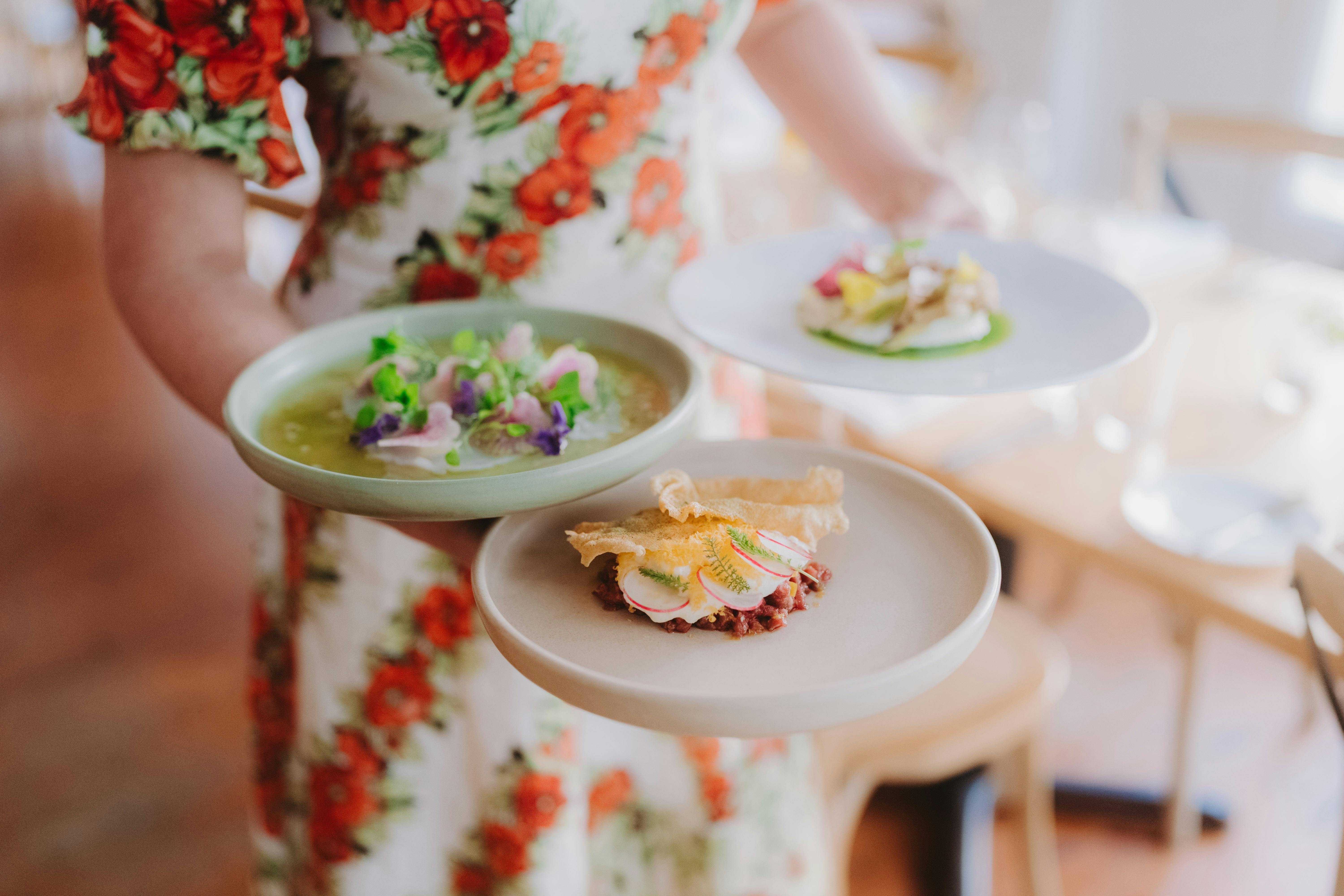 person carrying 3 plates of food