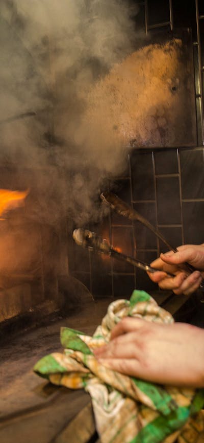 Chef in front of an open fire grill