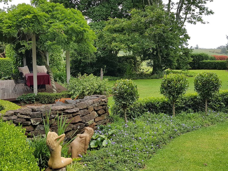 Garden with stone wall, hedges and large mature trees