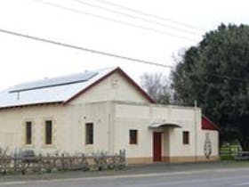 A photo of the Coonawarra Hall with white walls and a zincalume roof. The hall houses many functions