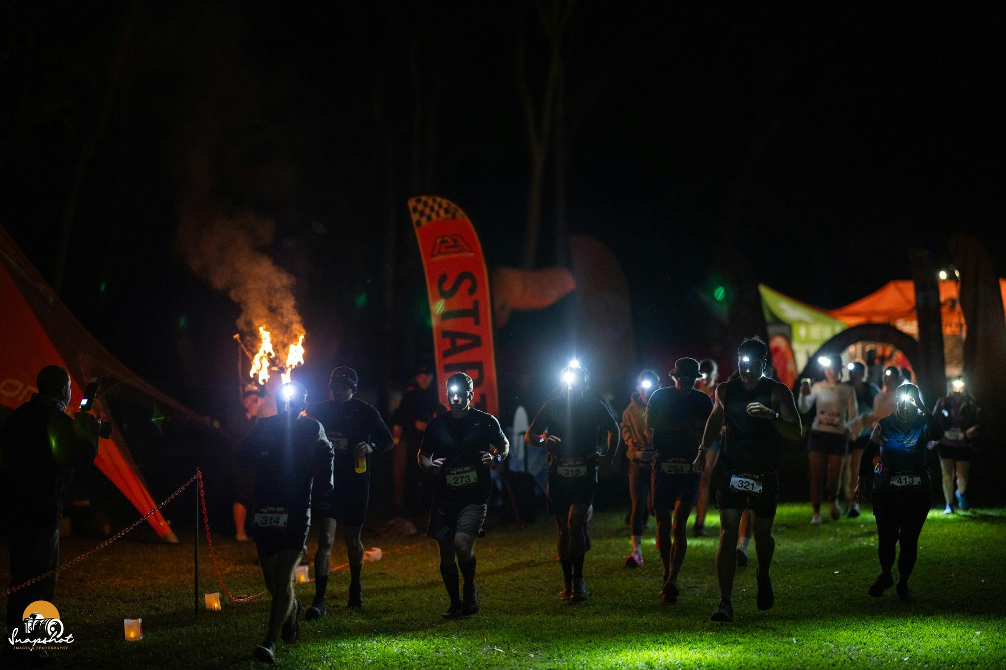 Runners with head torches starting at night