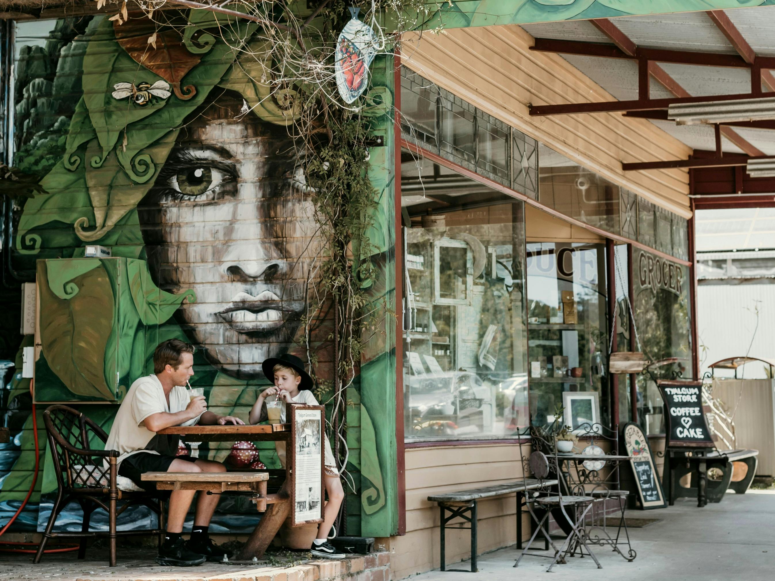 Dad and son having a cold drink outside Tyalgum General Store
