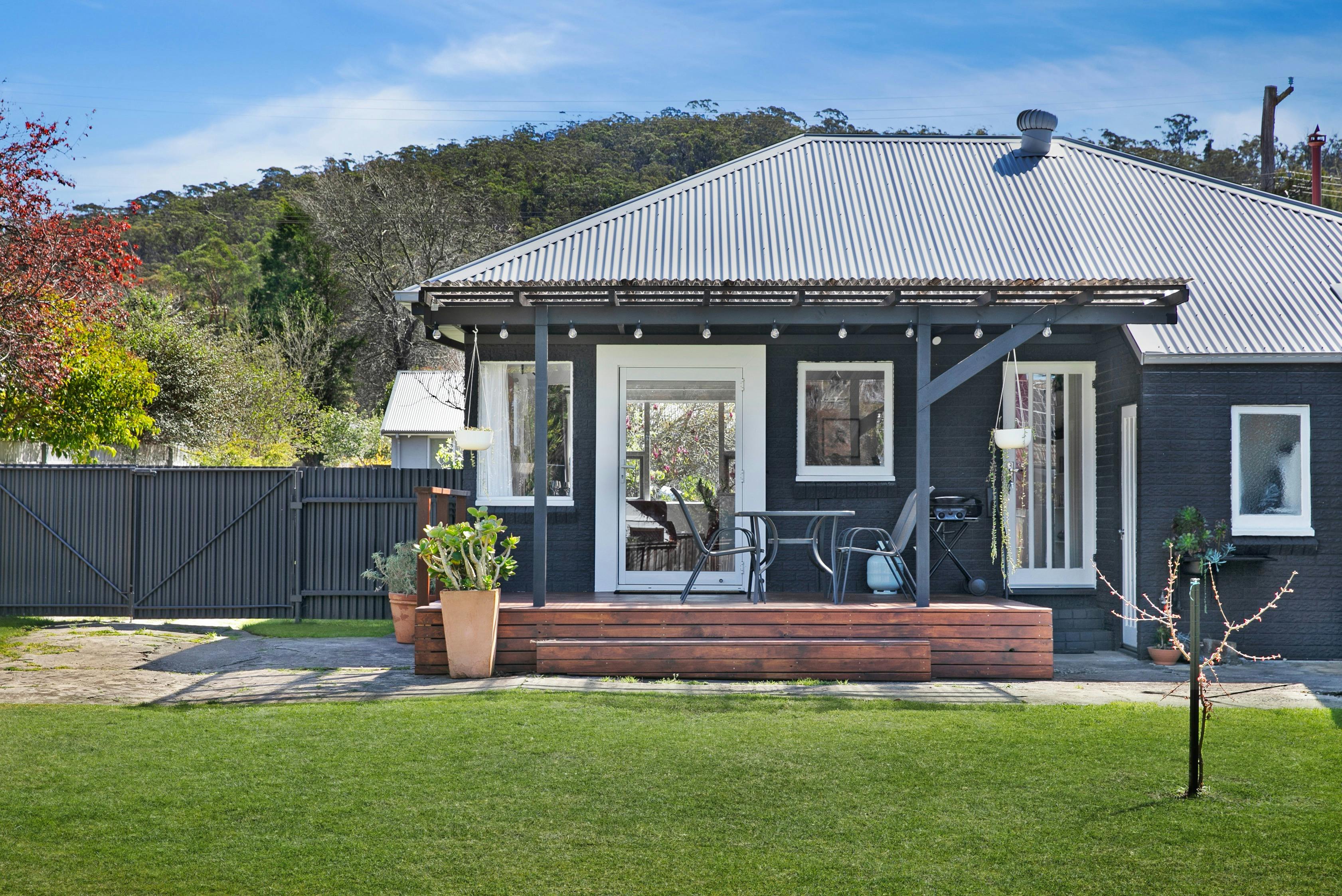 Black house ith deck, green grass