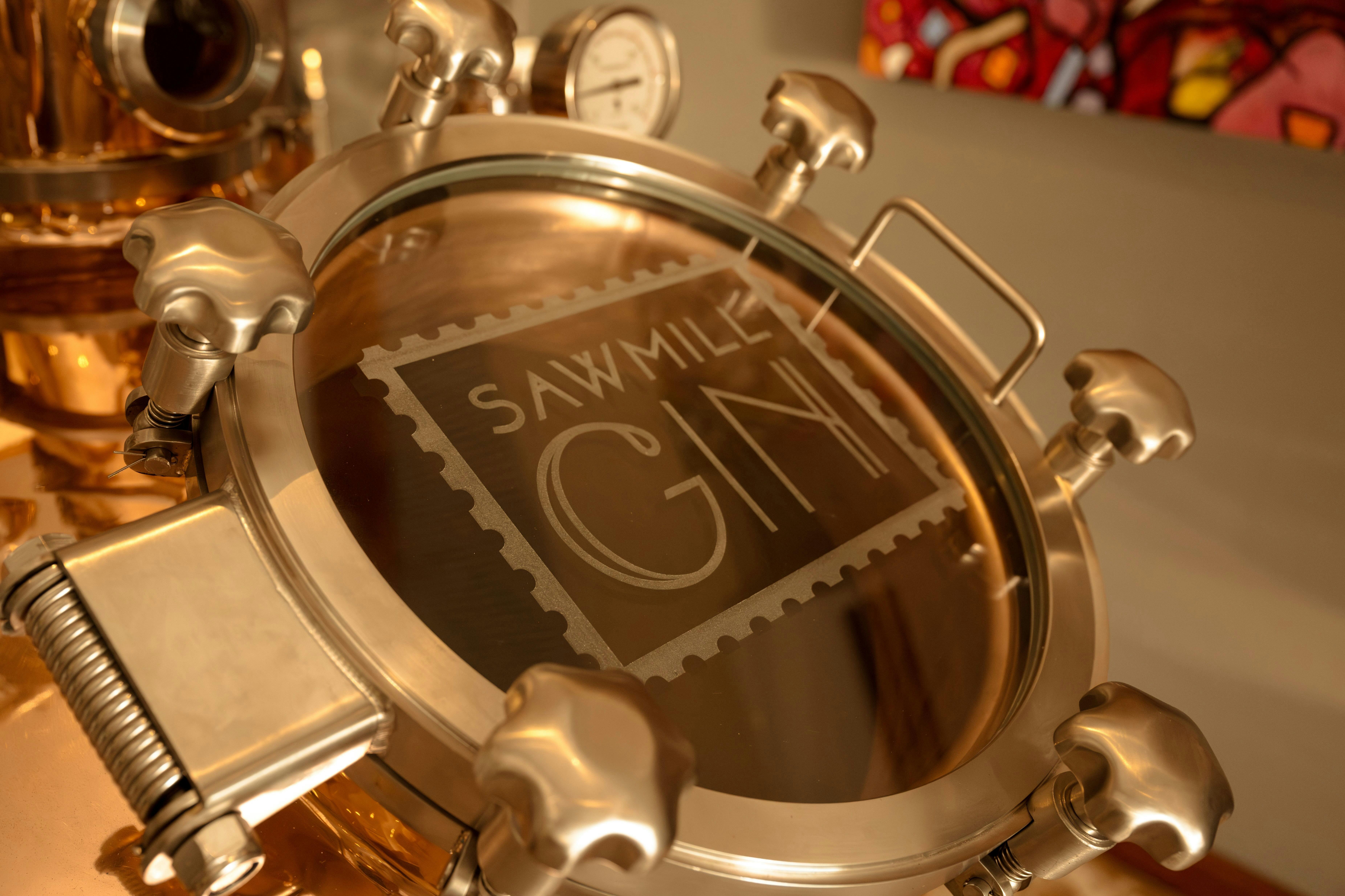 Copper Still showing manway with Sawmill gin Logo