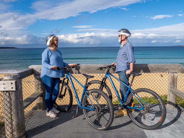 Two guests with bikes looking at Aslings Beach