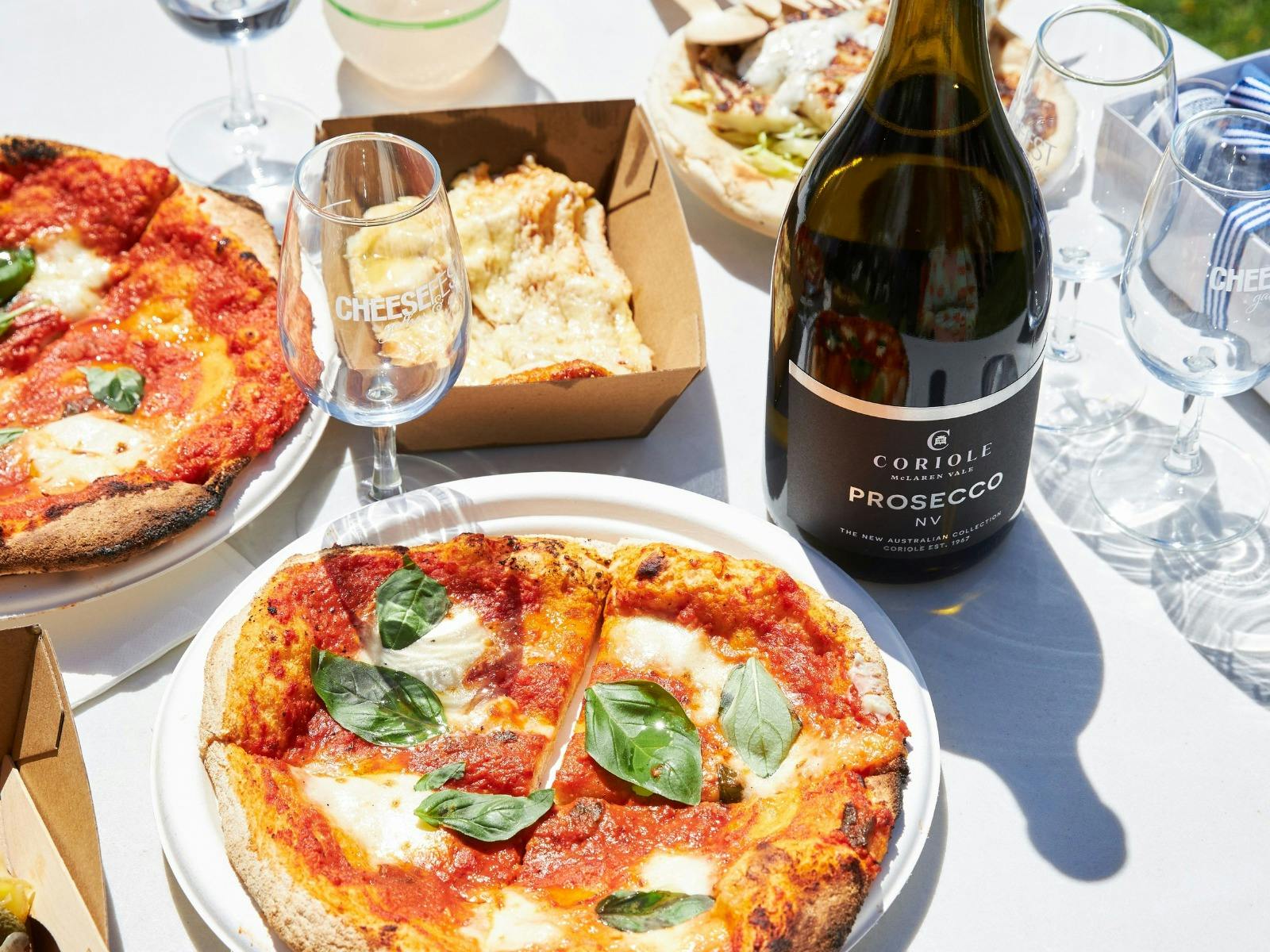 Pizza, Prosecco and Wine Glasses are on a table at CheeseFest