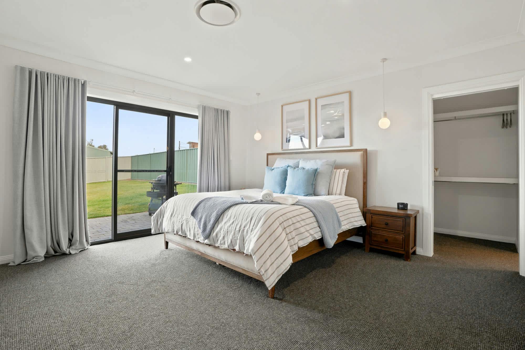 Main bedroom with king bed, side tables, large sliding door