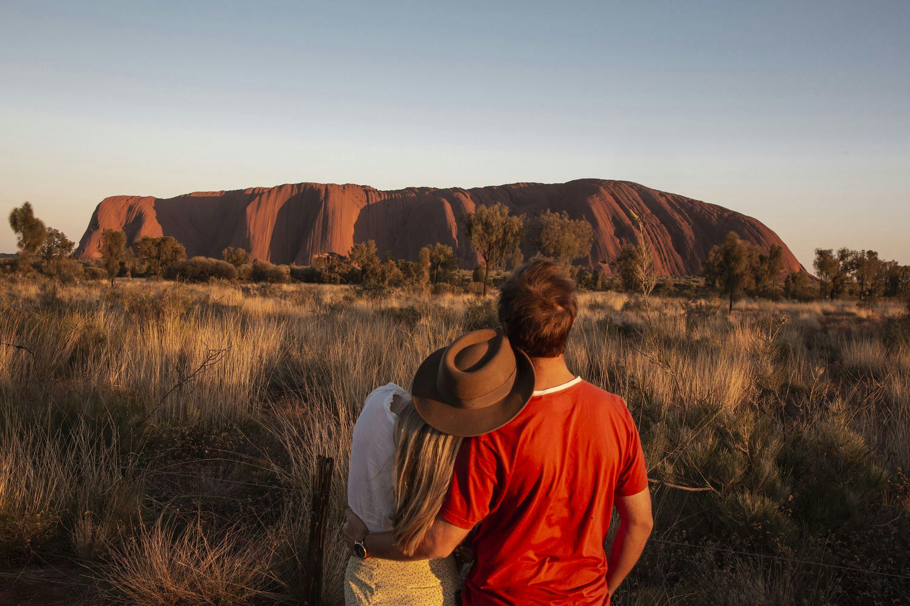 Couple looking at Uluru at sunrise