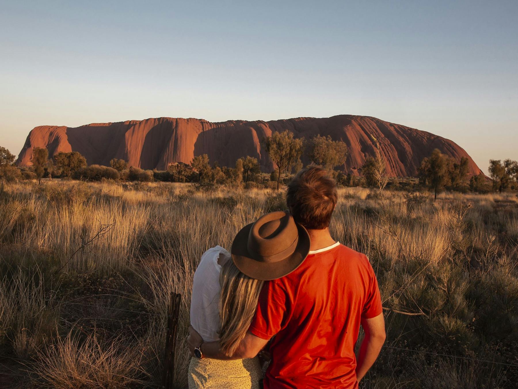 Couple looking at Uluru at sunrise