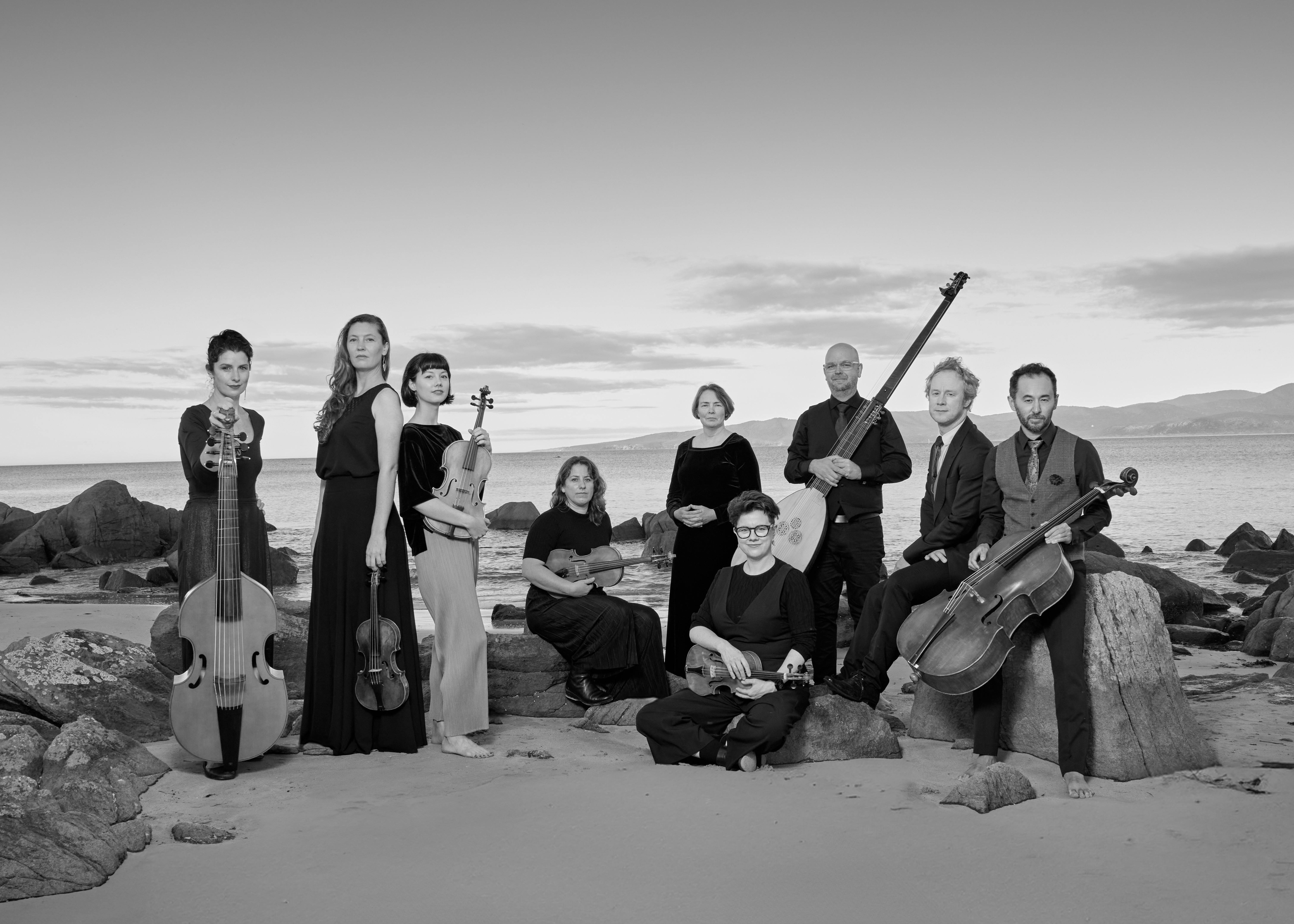 Memebers of VDB pose with their instruments on a beach.