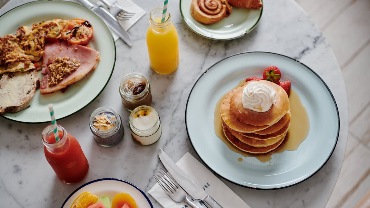 Breakfast dishes and juice on a marble table