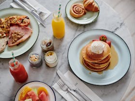 Breakfast dishes and juice on a marble table