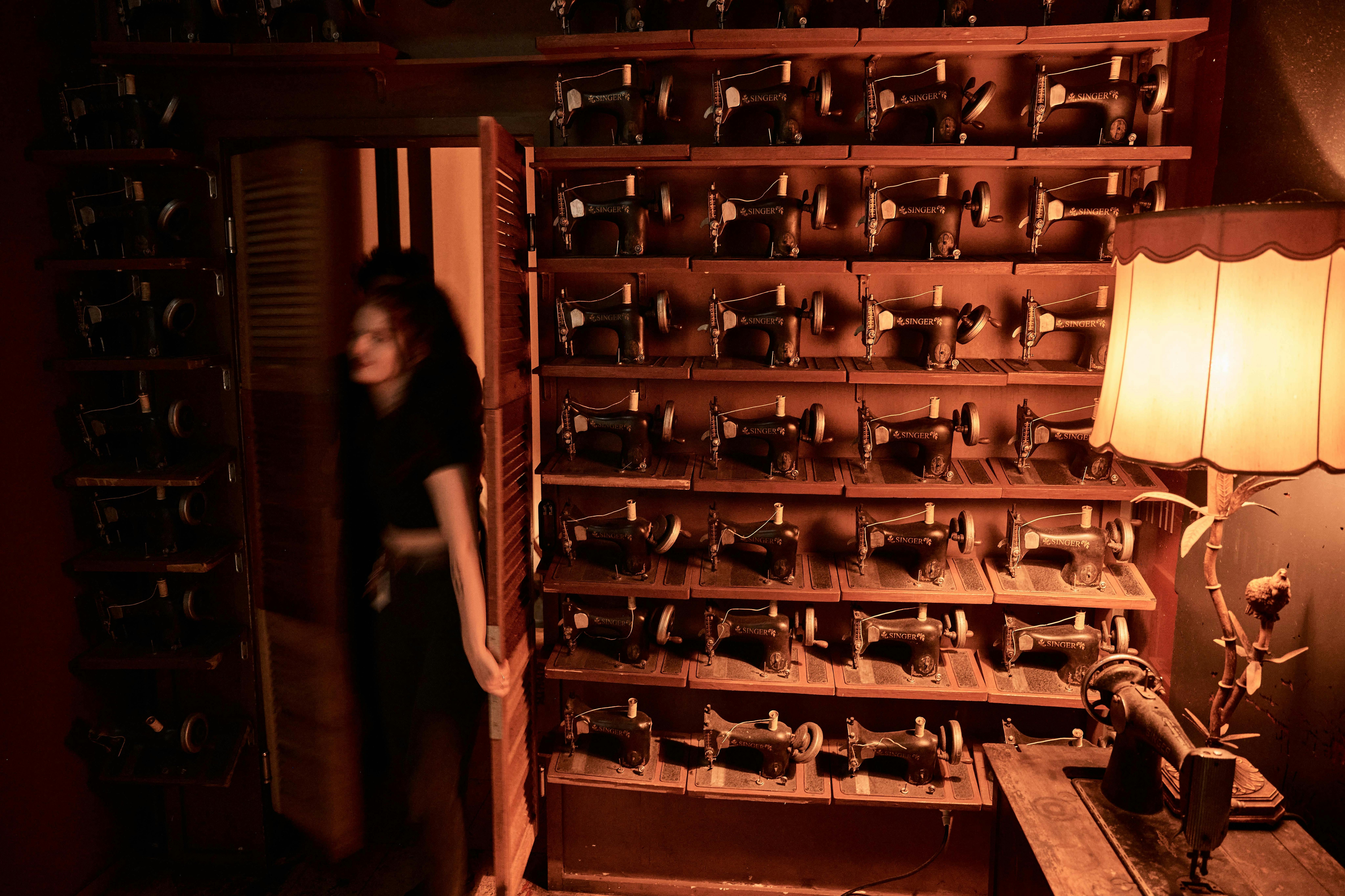A hidden entrance to a bar behind a wall of sewing machines