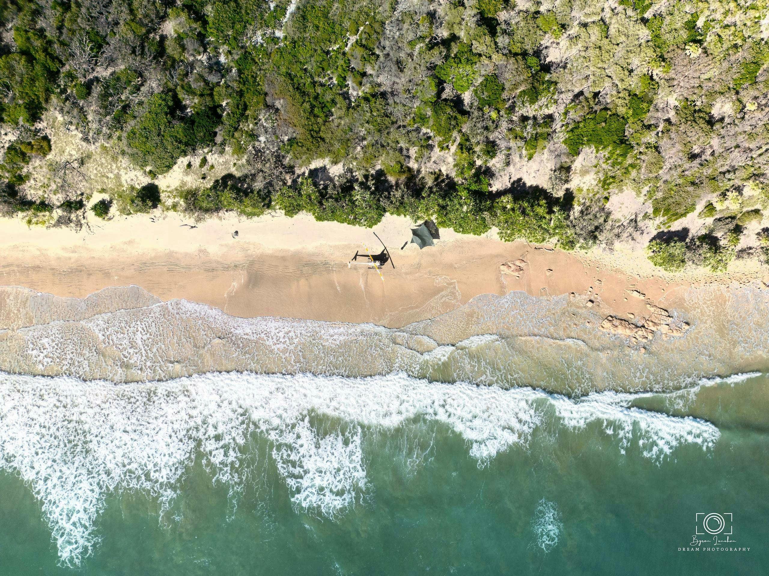 Helicopter and shade on the beach from above