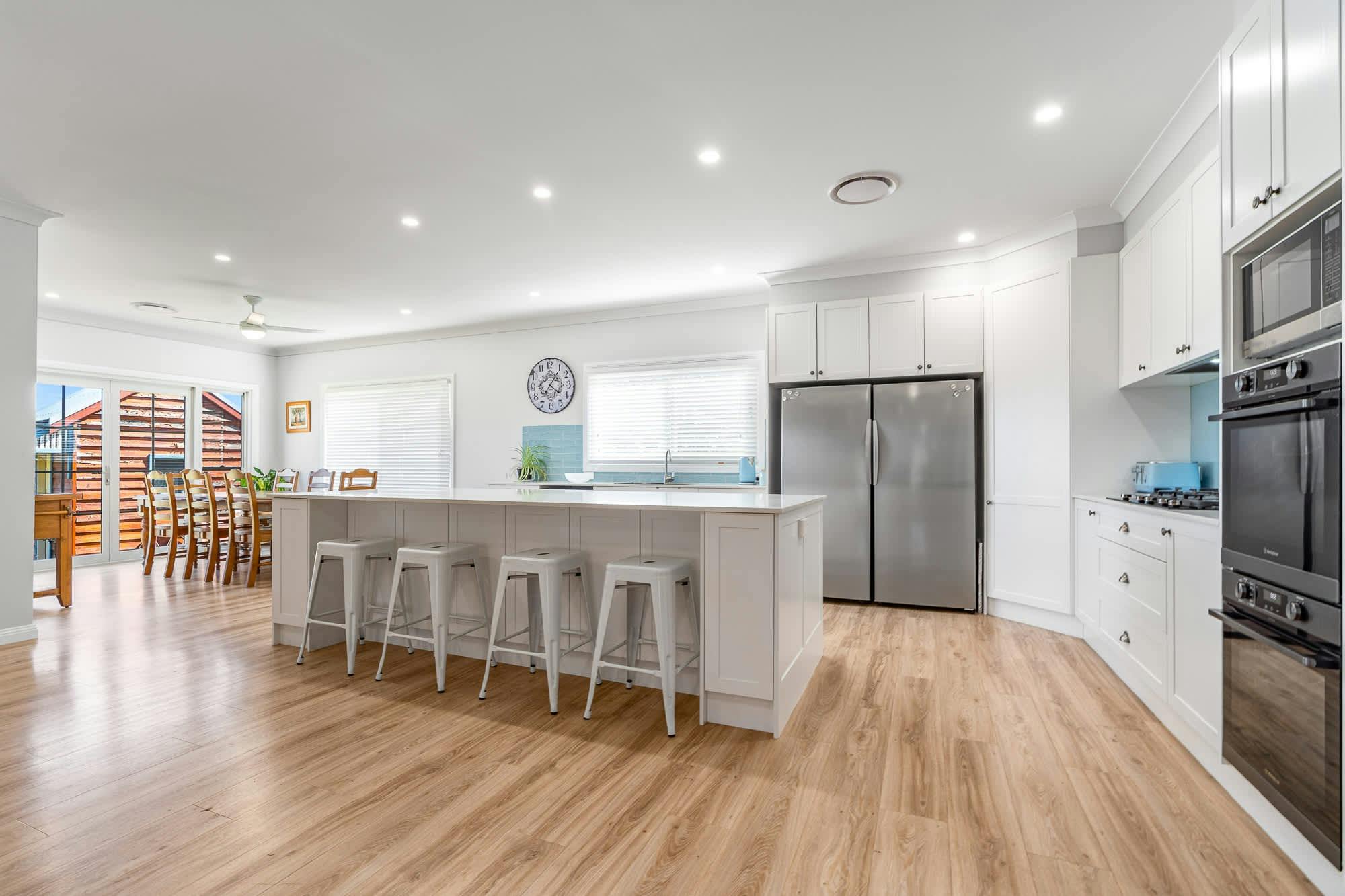 Island bench in a modern kitchen with wooden dining table and chairs